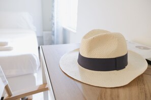 A straw hat with a dark band on a wooden surface in a hotel room. - Supernova (Savona)