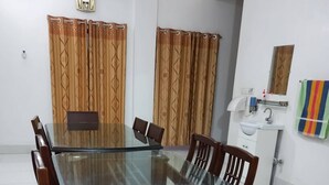 A conference room with a glass table and wooden chairs, a clock on the wall, and a bathroom with a sink and towel rack. - Kishoreganj Resort (Kishoreganj Sadar)