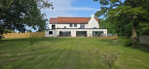 A modern two-story house with a large lawn and a wooden fence. - The Whitehouse Peterlee (Peterlee)