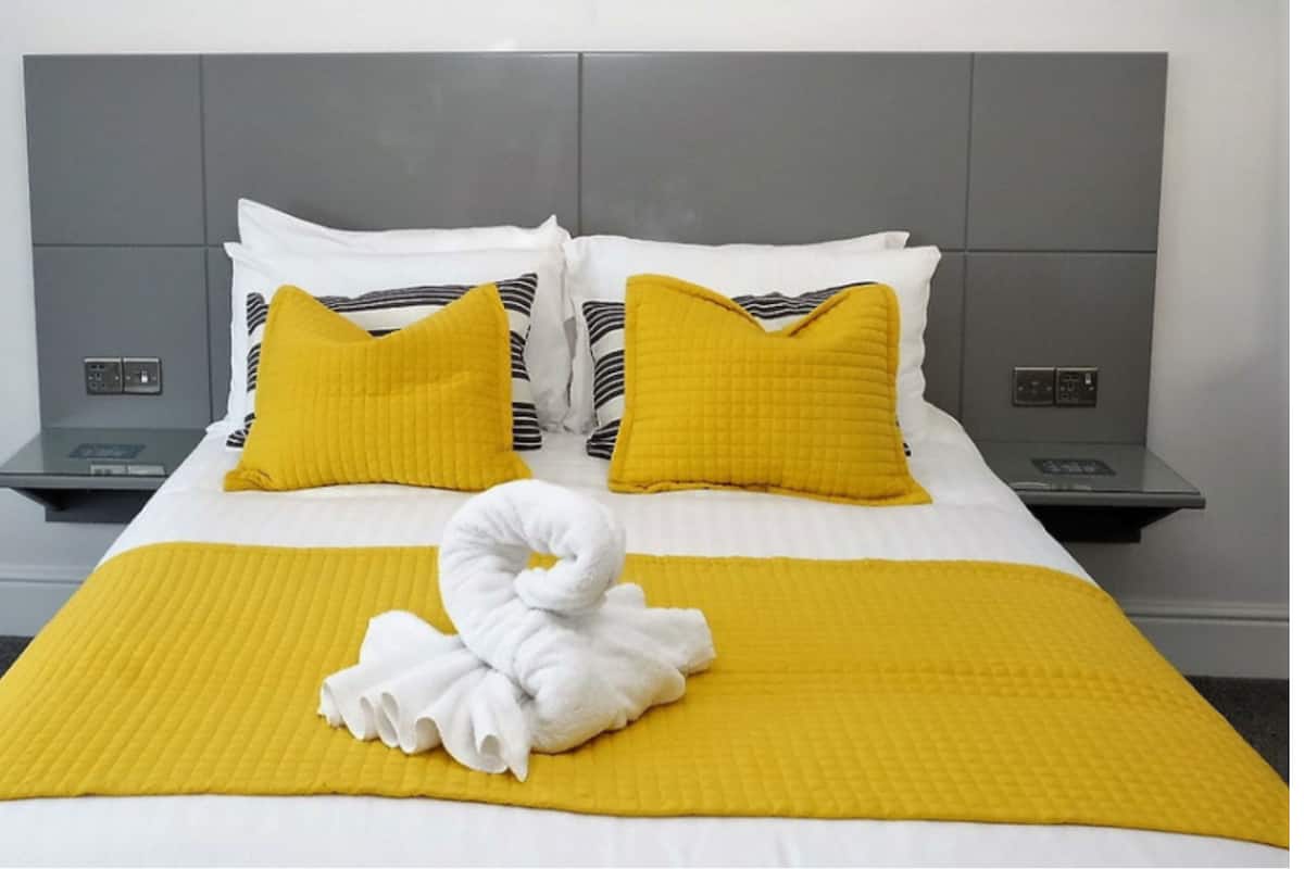 A hotel room with a bed, two nightstands, and a towel on the bed.