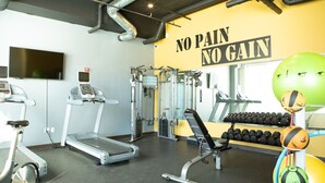 Et fitnesscenter med løbebånd, styrkemaskiner og træningsbolde.