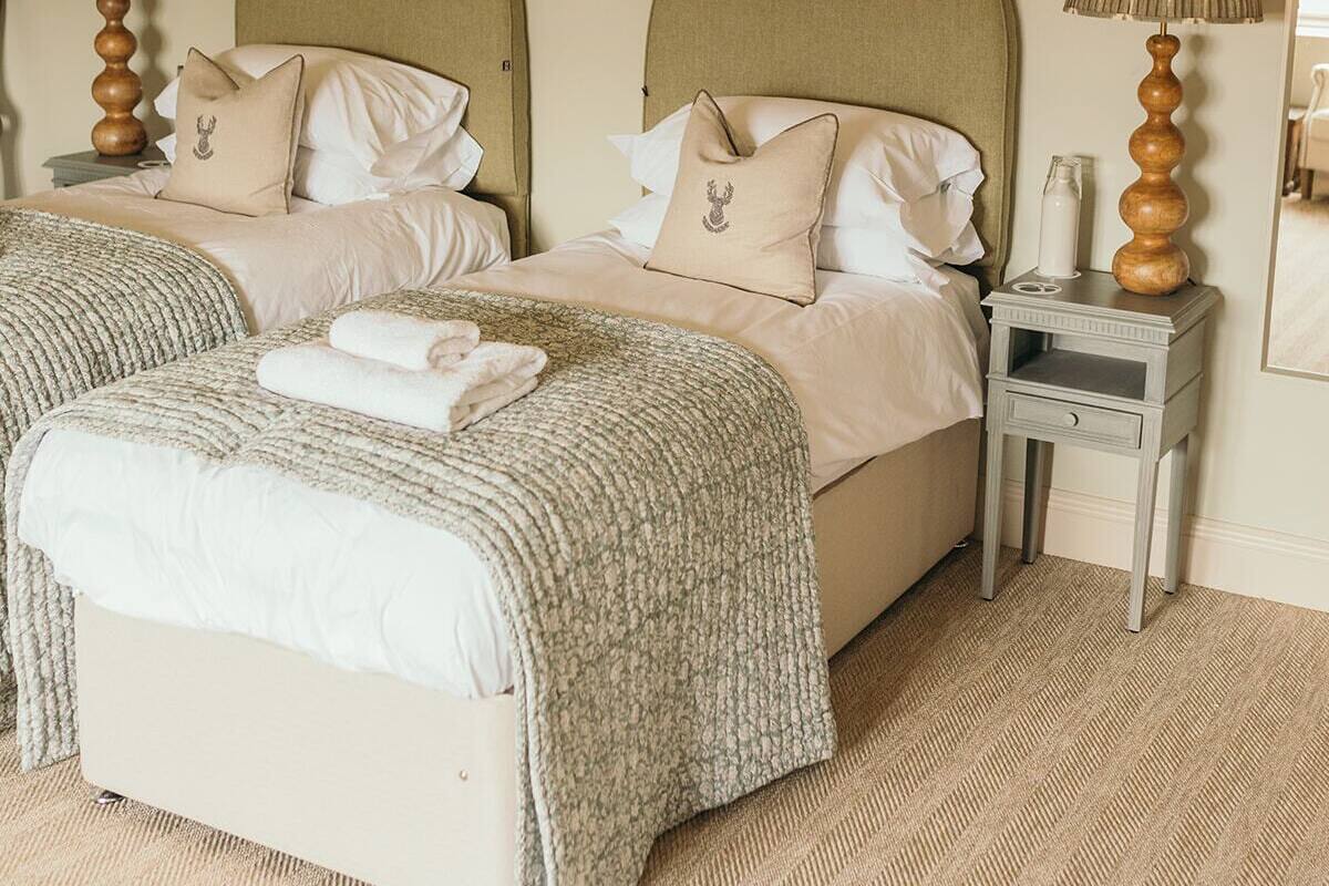 A double bed with a headboard, two bedside tables with lamps, and a large mirror on the wall.