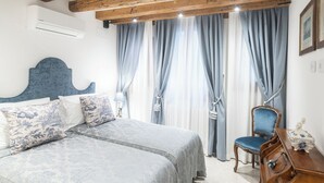 A bedroom with a bed, a wooden headboard, a chair, and a nightstand. - Giò&Giò Apartments (Venice)