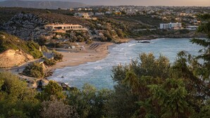 A coastal town with a beach, rocky terrain, and buildings in the background. - Villa Anton by Cura Villas Collection (Chania)