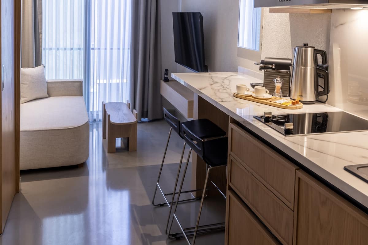 Cozinha moderna com bancada de mármore, cafeteira e exaustor Siemens.