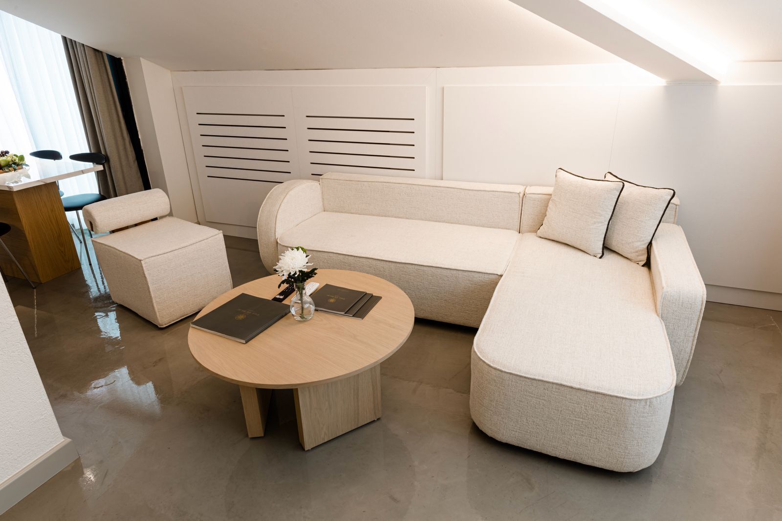 Un salon moderne avec un canapé d’angle, une petite table ronde et une table basse.
