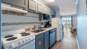 A modern kitchen with white cabinets, a microwave, a stove, and a dishwasher. - Fall Dates Available! Quick Walk to Beach! Perfect for Families! (Panama City Beach)