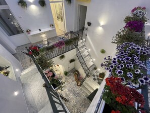 A multi-level interior with a staircase, potted plants, and a tiled floor. - Donna Grazia  (Gallipoli)