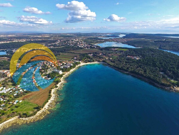 Vue aérienne d’une ville côtière, avec une côte bien définie, une petite baie et une vaste étendue d’eau.