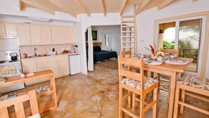 Une cuisine compacte avec des meubles en bois et un coin repas avec une table dressée pour deux personnes.