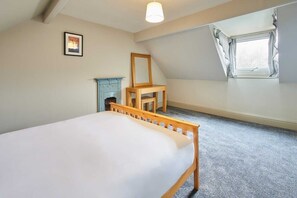 A bedroom with a single bed, a small table, a chair, a fireplace, and a window. - Host & Stay | Moors Edge (Charltons)
