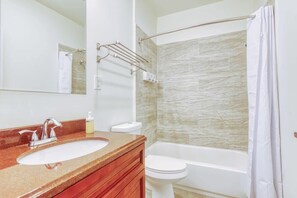 Une salle de bain avec un lavabo, des toilettes et une baignoire.