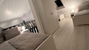 Una camera da letto con letto a soppalco, un armadio, una scrivania e una TV.