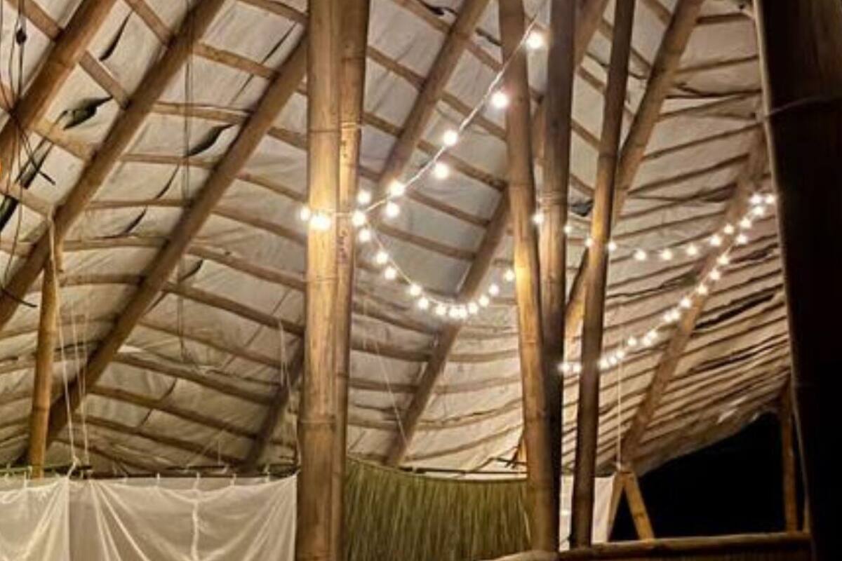 Een rustieke houten constructie met een hoge plafond en sfeerverlichting.