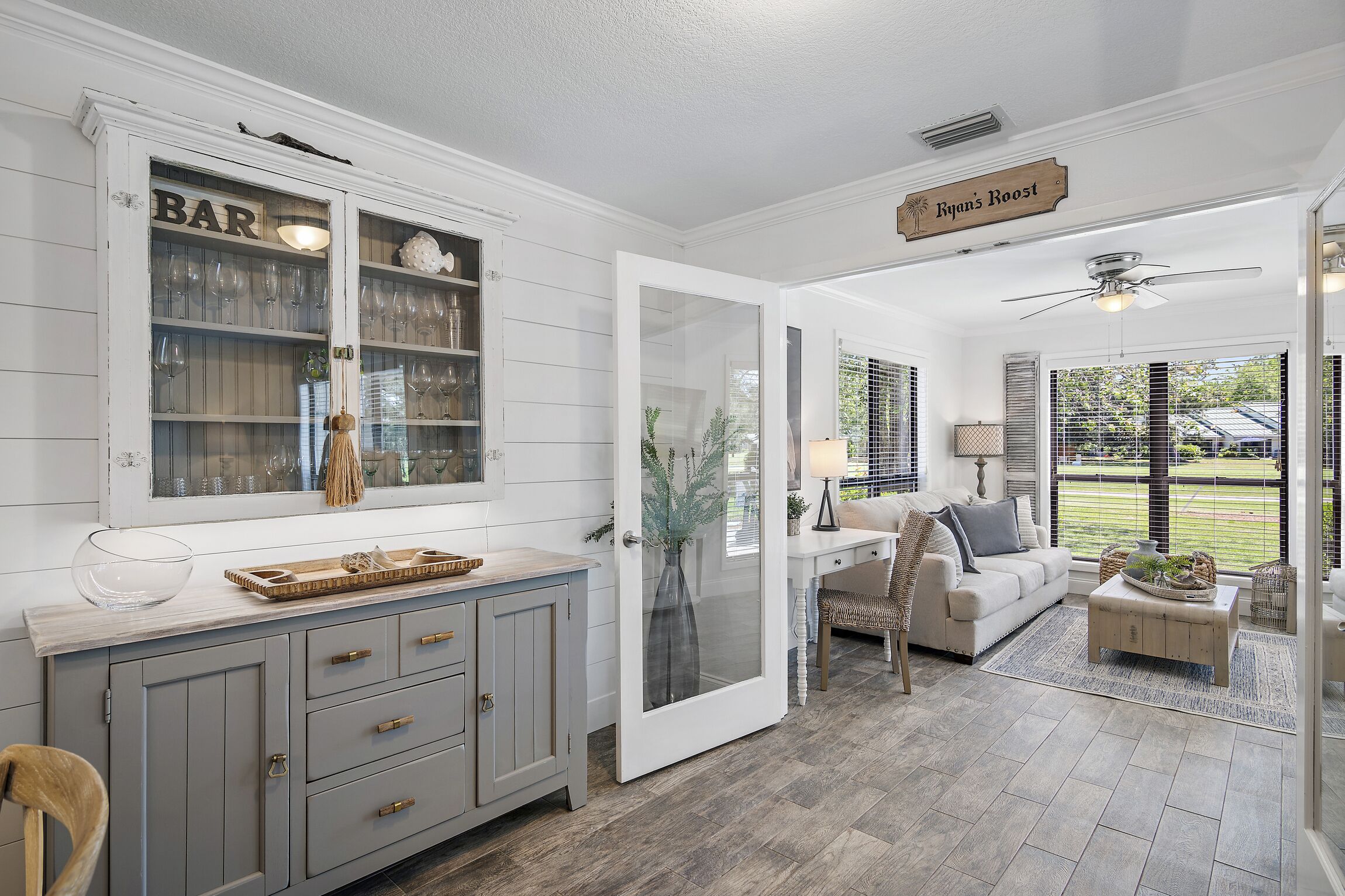 A kitchen with a bar area, a dining area with a sofa, and a view of the outdoors.