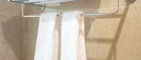 Un baño con toallero y toallas dobladas.