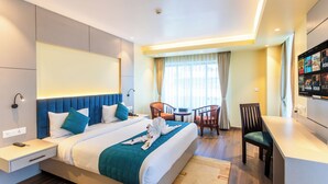 Una habitación de hotel moderna con una cama grande, un escritorio y una zona de estar.