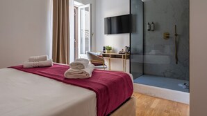 A hotel room with a bed, a desk, a shower, and a TV. - Decimo Meridio- At Spanish Steps- (Rome)