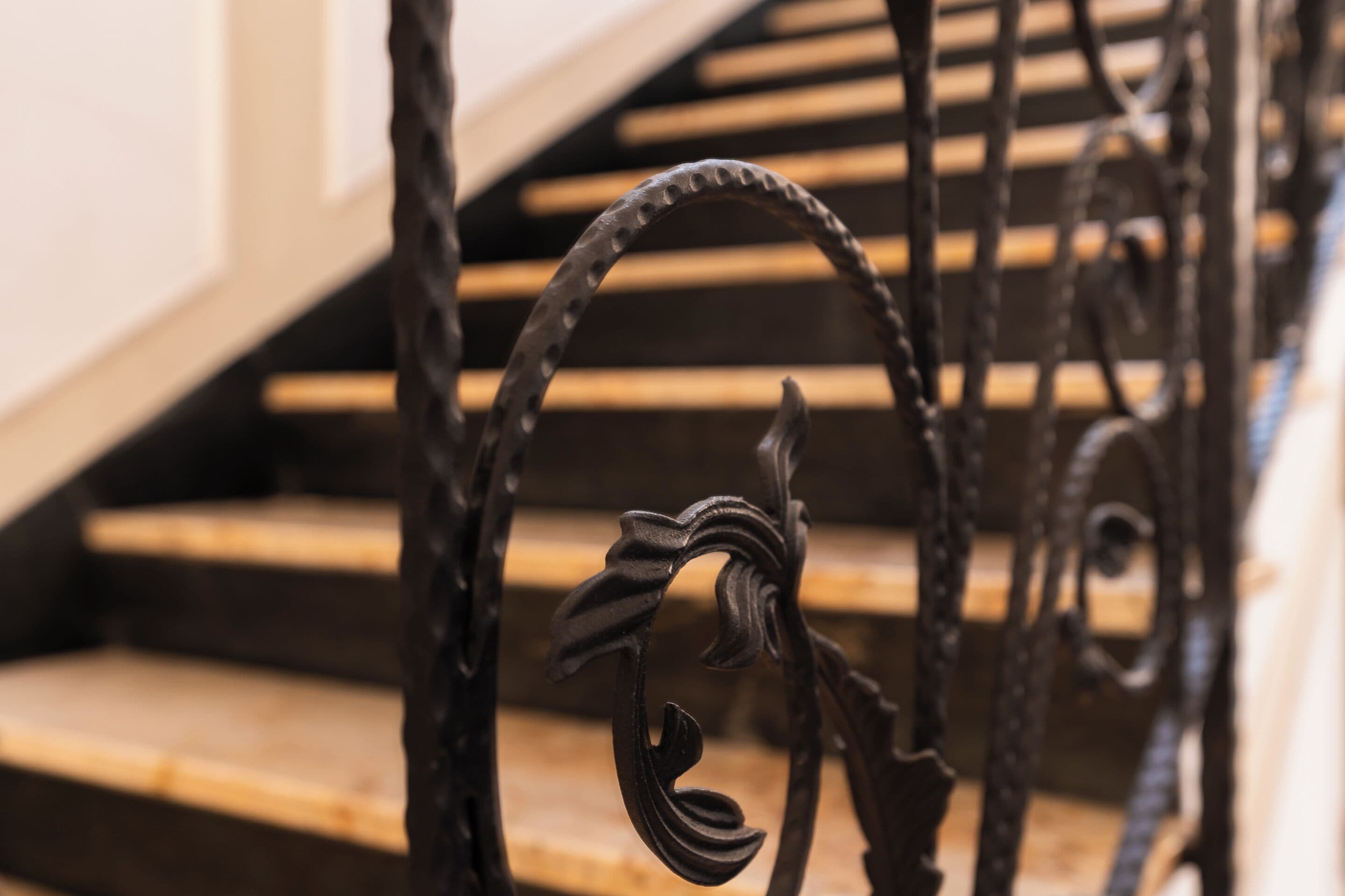 Un gros plan d’une rampe d’escalier en fer forgé ornée de motifs complexes.