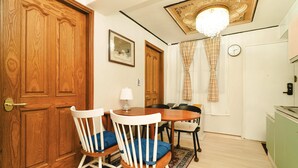 A dining area with a wooden table and chairs, a chandelier, and a clock on the wall. - Oak&Co (Seoul)