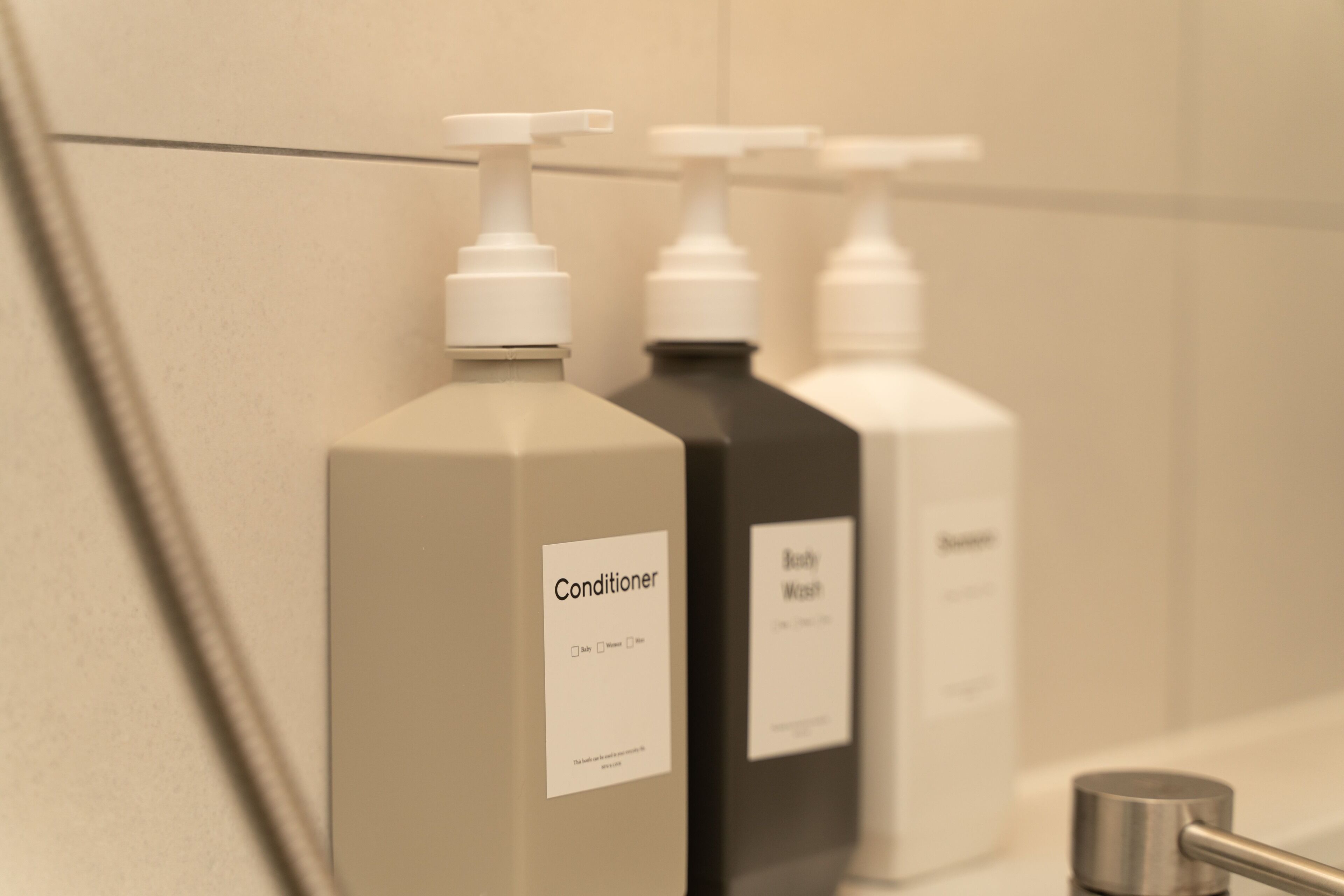 A row of bathroom dispensers labeled with different products.