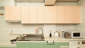 A kitchen with a sink, a toaster, a microwave, and a washing machine. - Oak&Co (Seoul)