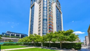 Un edifici alt i modern amb façana corbada i diversos balcons.
