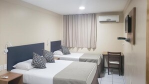 A hotel room with two beds, a desk, a chair, an air conditioning unit, and a television mounted on the wall. - Villa Park Fortaleza (Fortaleza)