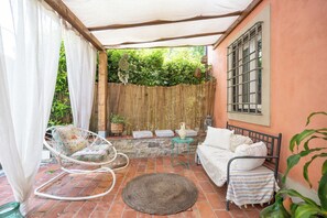 A cozy outdoor patio with a bed, chairs, and a table. - A detached villa from the 1800s, 250 square meters in size, completely renovated. Ocean view. (Lucca)