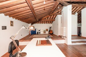 A room with a wooden ceiling, a chessboard, a desk with a lamp, and a guitar. - A detached villa from the 1800s, 250 square meters in size, completely renovated. Ocean view. (Lucca)