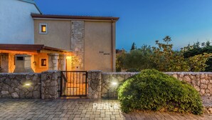 A two-story building with a stone wall entrance, a small window, and a door. - Holiday house EMY with pool in Krk 600m from the beach (Krk)