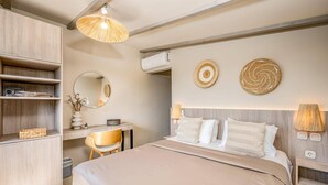 Ein Schlafzimmer mit einem Bett, einem Schreibtisch, einem Stuhl, einem Kleiderschrank und einer Pendelleuchte.