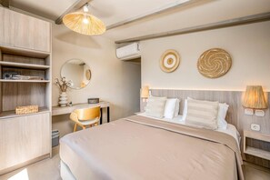 Una camera da letto con un letto, una scrivania, una sedia, un armadio e una lampada a sospensione.