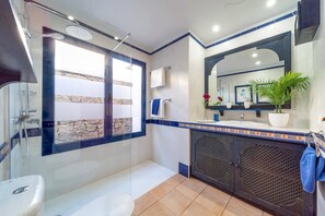 A modern bathroom with a bathtub, a shower, a sink, and a large mirror. - Villa Seasol 2 by Villa Plus (Playa Blanca)