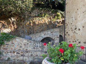 Un escalier en pierre avec des rampes métalliques, menant à une avancée rocheuse.