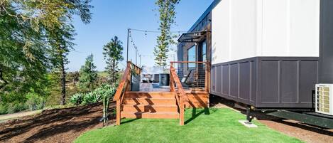 A modern building with a wooden staircase leading to a glass door entrance.