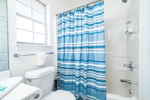 Ein Badezimmer mit Toilette, Badewanne und Fenster.