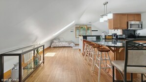 Un moderno apartamento tipo loft con cocina, comedor y una cama en un entrepiso.
