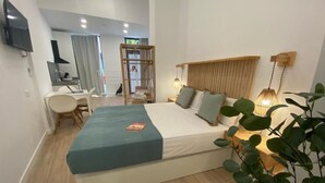 A bedroom with a bed, bedside lamps, a desk, and a chair. - Travel Habitat Cabanyal Loft 3 (Valencia / València)