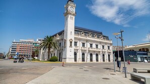 A historic building with a clock tower, a large open plaza, and palm trees. - Travel Habitat Cabanyal Loft 3 (Valencia / València)