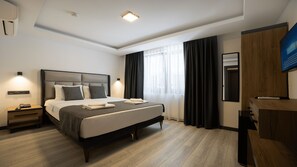 A modern hotel room with a large bed, bedside tables, a desk, and a flat-screen TV. - Kriti Hotel Antalya (Antalya)