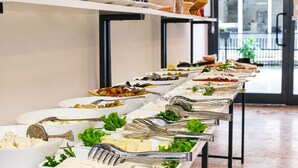 Una barra de buffet con distintos alimentos y utensilios.