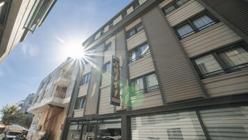 Un edificio de varios pisos con un diseño arquitectónico moderno, que destaca por sus grandes ventanales y un cartel llamativo.