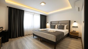A modern hotel room with a large bed, bedside lamps, a desk, and a window with curtains. - Kriti Hotel Antalya (Antalya)