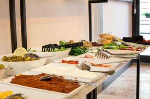 A buffet with various food items and utensils.