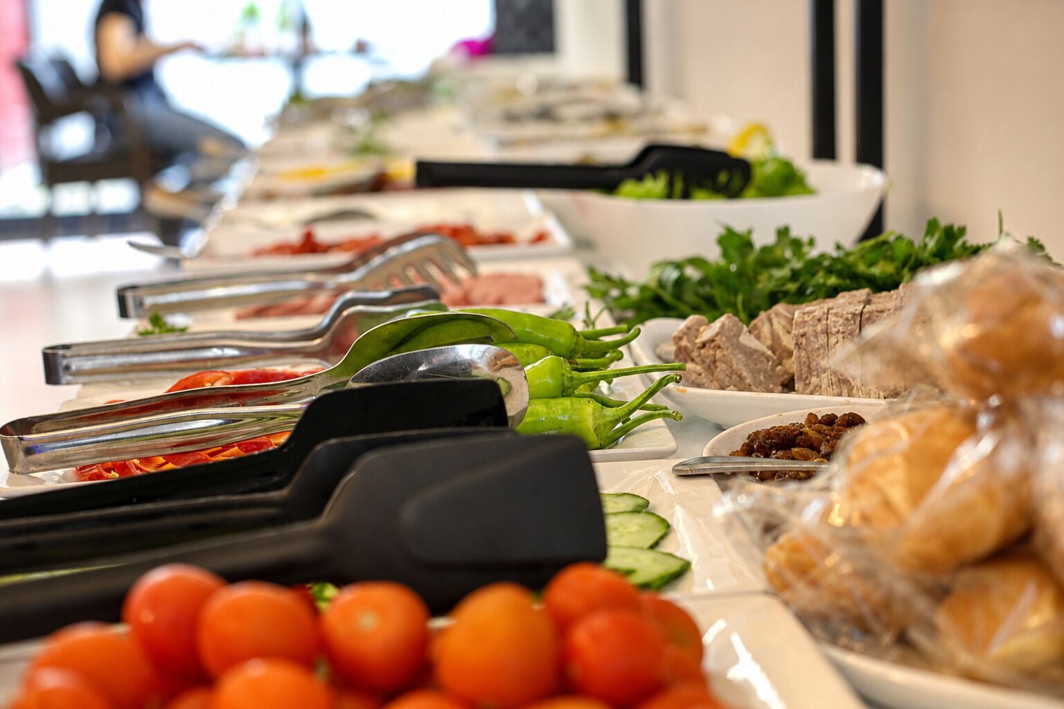 A buffet with various food items and utensils.
