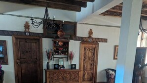 A spacious room with a tiled floor, wooden furniture, and a chandelier.