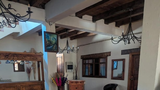 A spacious room with a tiled floor, wooden furniture, and a chandelier.