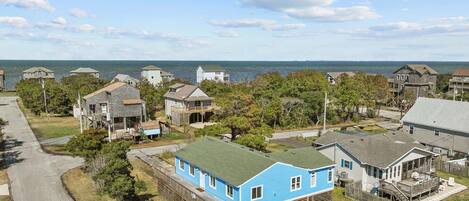 Una zona residencial con casas, una carretera y vistas al mar.