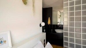 A modern bathroom with a white sink, black countertop, and a mirror. - Hoppersgr- Amazing apt in the heart of Athens - 4 (Athina)
